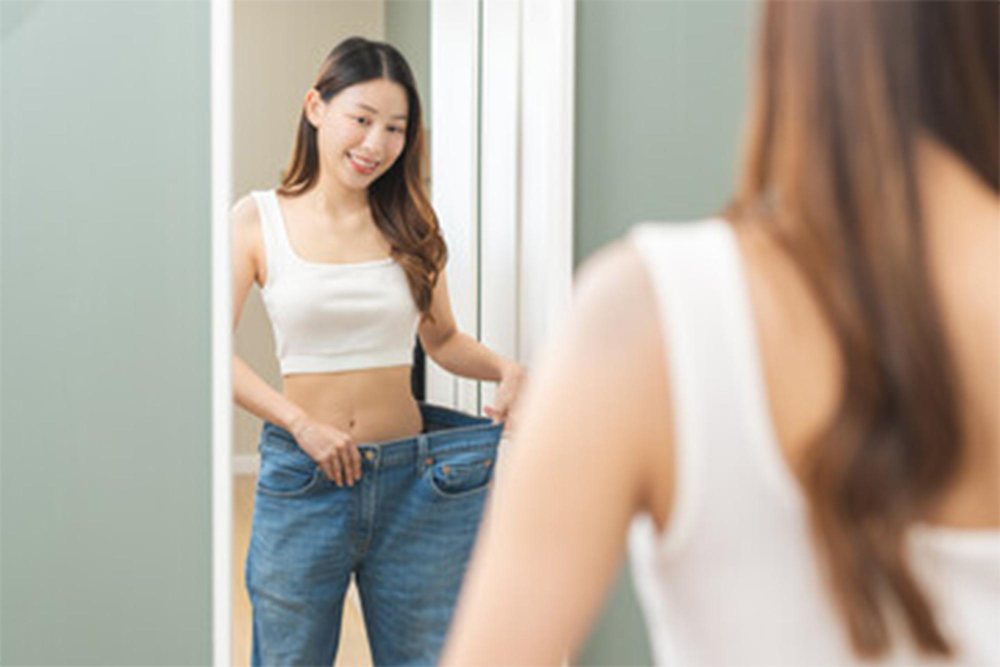 A young woman happy with weight loss.