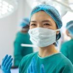 A surgeon in a surgical mask and gloves in an operation room. (illustration)